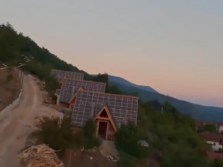 Dron preko krovova vikendica u sumrak